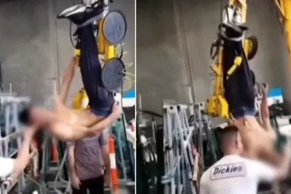 Apprentice being bullied while hanging upside down underneath a crane at work