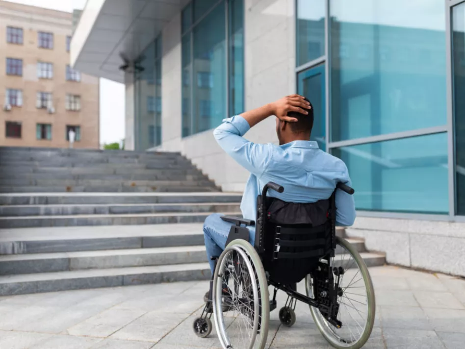 Man in wheelchair approaches building