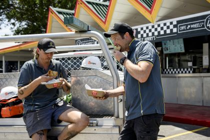 tradies eating tradie pies in the back of a ute