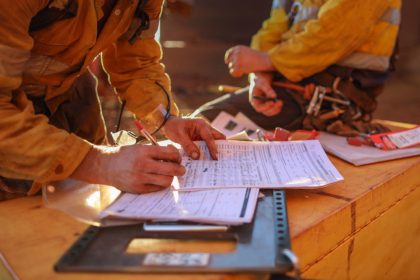 Construction workers signing paper work on site