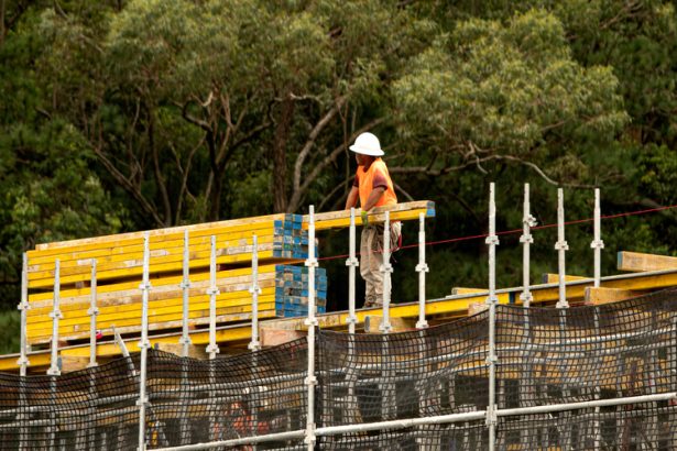 Construction worker in high viz on home rood in construction site