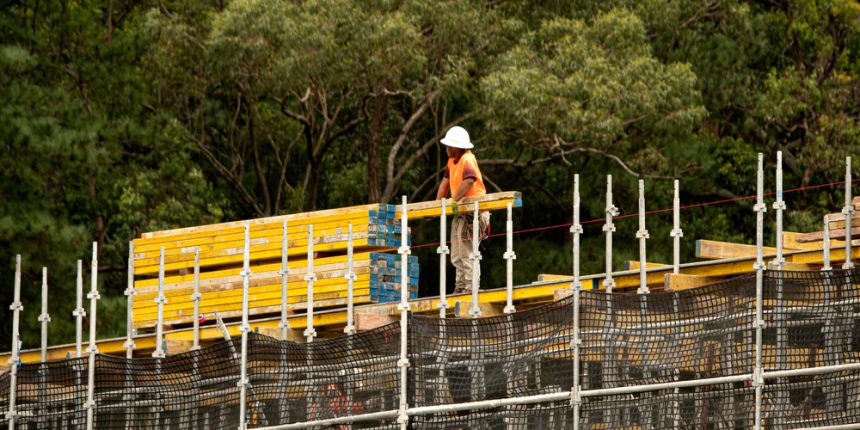 Construction worker in high viz on home rood in construction site