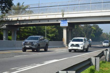 Toyota Hilux woork utes driving side by side down the motorway underneath bridge