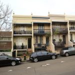 Duplex homes side-by-side in Sydney city street behind car