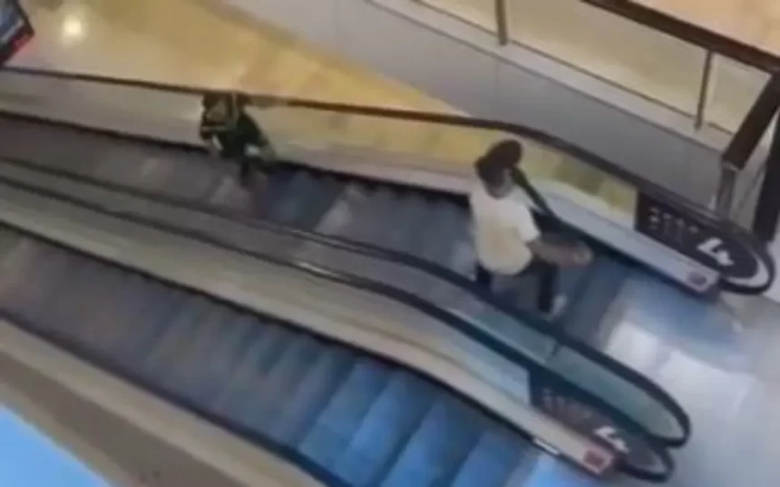 Tradie fending off stabber on escalator with bollard