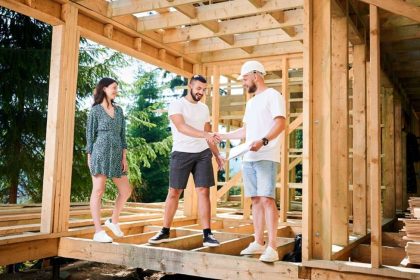Couple looking at home under construction and talking to tradie