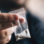 Bag of cocaine held out by man