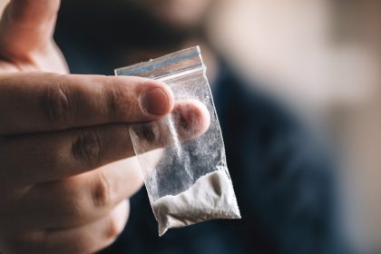 Bag of cocaine held out by man