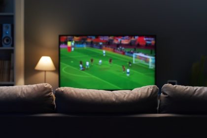 Sport playing on television in front of couch in living room