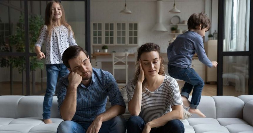 couple on couch sad while kids play around them