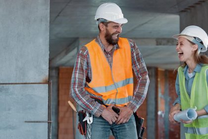 Tradies in hard hats laughing on work site