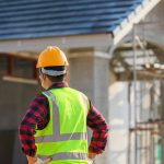 men in high vis and hard hats pointing at home on construction site