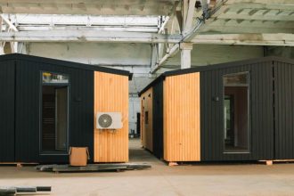 Two prefab homes sitting in industrial warehouse