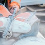 Man cutting into concrete with concrete saw