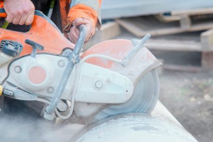 Man cutting into concrete with concrete saw