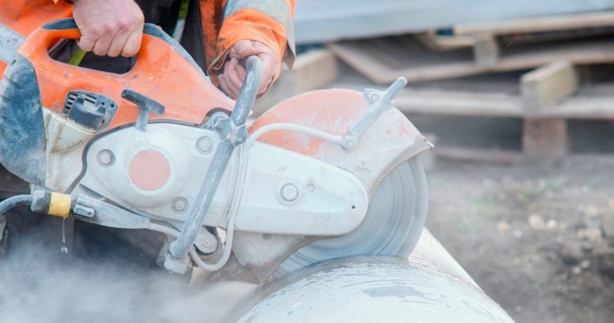 Man cutting into concrete with concrete saw