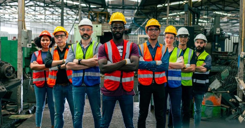 Migrant workers standing side by side on job site