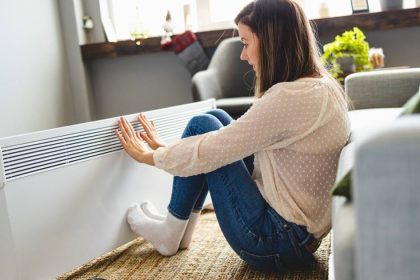 Woman next to a heater at home