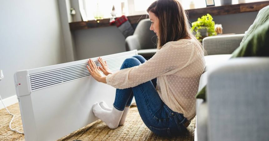 Woman next to a heater at home