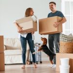 Man and woman surrounded by moving boxes in house