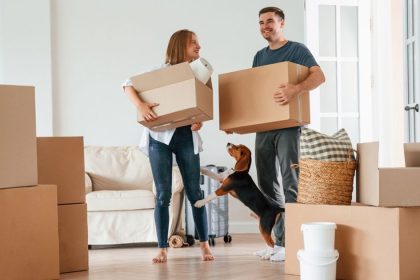 Man and woman surrounded by moving boxes in house