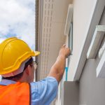 Building inspector pointing at home