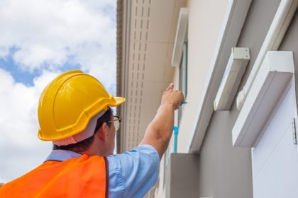 Building inspector pointing at home