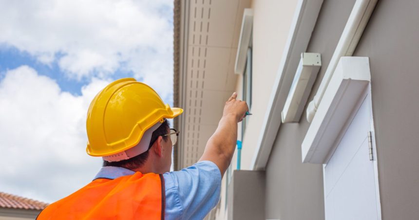 Building inspector pointing at home