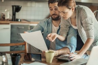 Couple looking over expensive insurance bill