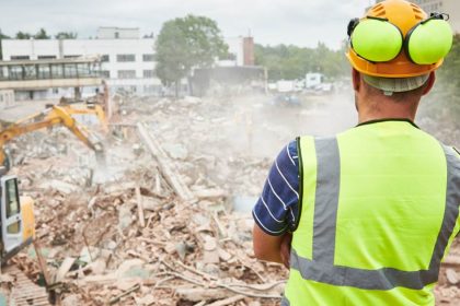 construction worker looks at construction waste on job site