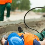 Apprentice lying on ground after being injured at work