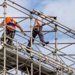 Workers harnessed in on scaffold