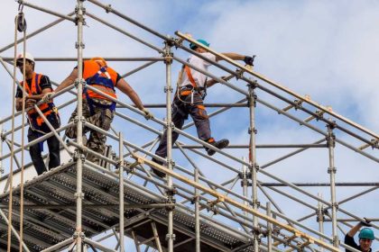 Workers harnessed in on scaffold