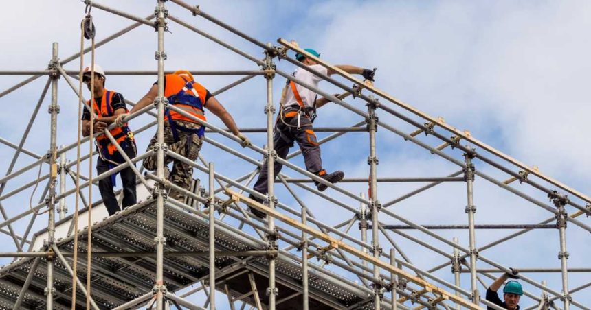 Workers harnessed in on scaffold