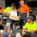 Tradies enjoying aa box of Krispy Kremes on the job