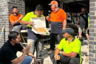 Tradies enjoying aa box of Krispy Kremes on the job