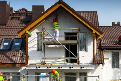 construction workers surrounding house being built