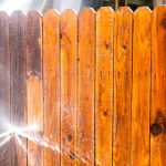 fence being cleaned with hose