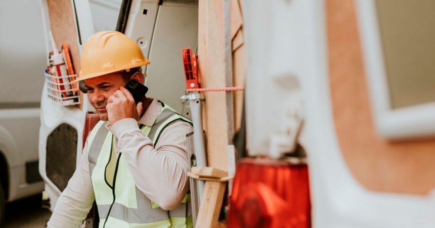 Tradie on phone call in back of work van