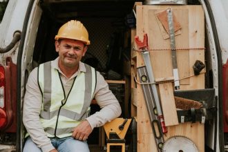 Tradie sitting in the back of a van with his tools