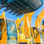 Second-hand construction equipment sitting in lot side-by-side