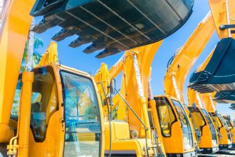 Second-hand construction equipment sitting in lot side-by-side