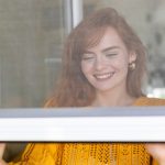 a woman closes fly screen