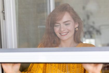 a woman closes fly screen