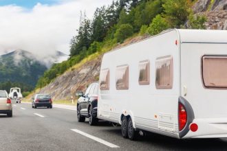 caravan being towed by car on highway