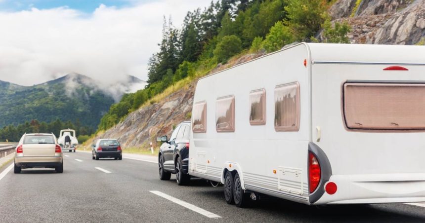 caravan being towed by car on highway