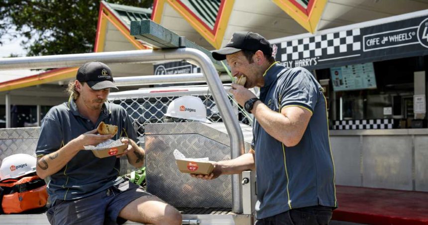 two tradies eat a pie